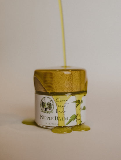Jar of Nipple Balm with a natural ingredient pouring over it.