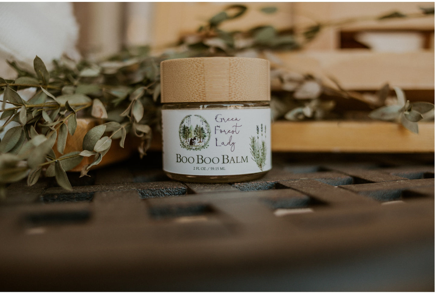 Jar of Boo Boo Balm surrounded by decorative leaves