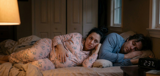 Pregnant Women with insomnia leaning onto husband who is fast asleep.