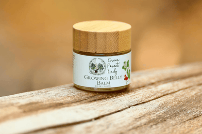 Glass jar of Growing Belly Balm sitting on a wood table 