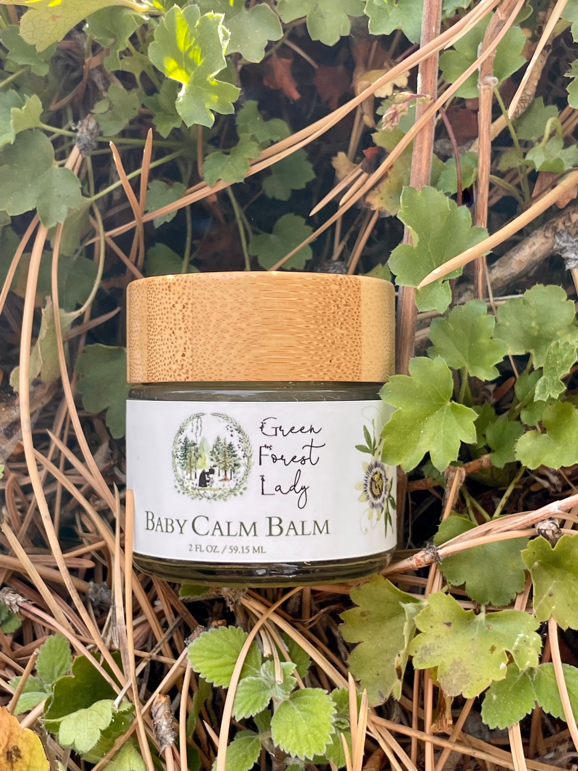 Jar of Baby Calm Balm on foliage in a forest 